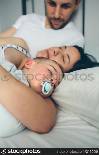Man looking at his wife and son sleeping. Man looking his wife and son