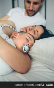 Man looking at his wife and son sleeping. Man looking his wife and son