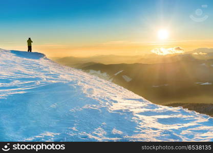 Man looking at sunset. Man looking at sunset, sun and beautiful winter mountains with snow