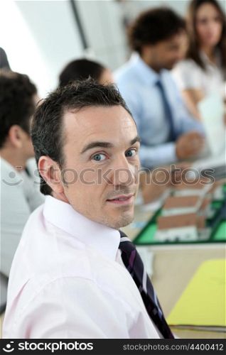 Man looking at the camera during a work meeting discussing a new housing estate