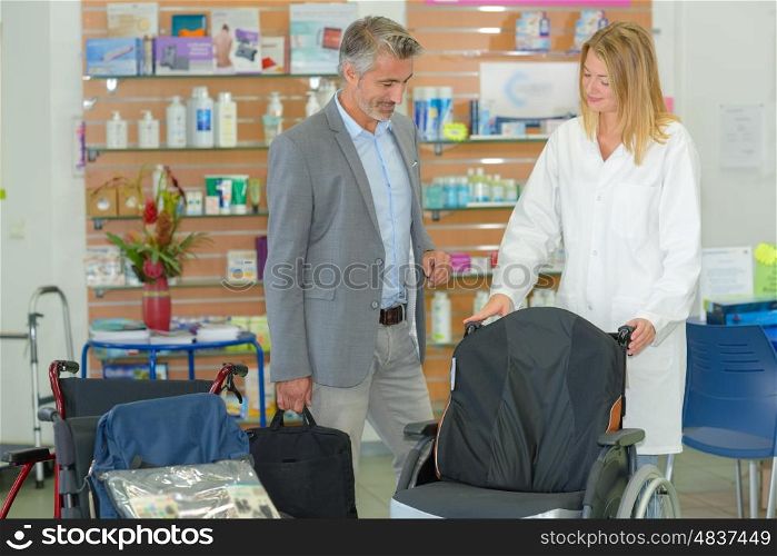 Man looking at wheelchair in medical supplies shop