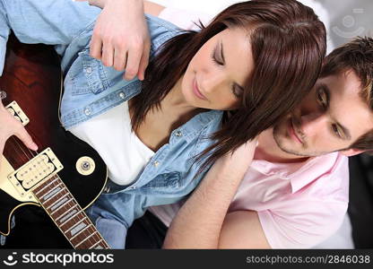 Man looking girl playing guitar
