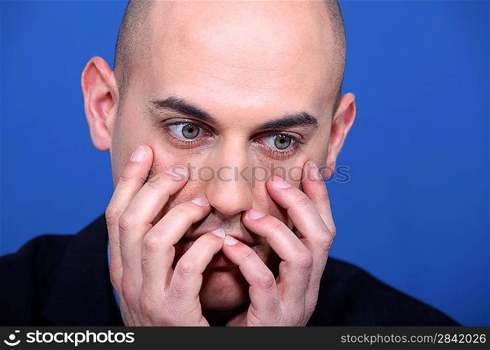 man looking horrified with hands to face