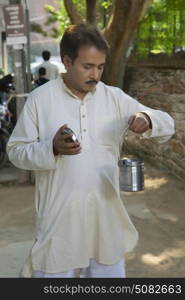 Man looking into a milk canister