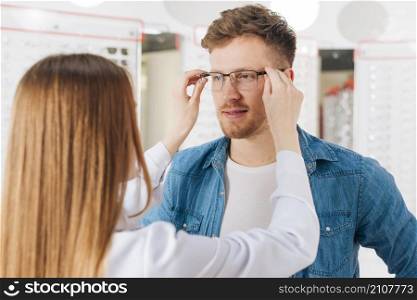 man looking new glasses optometrist