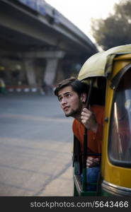 Man looking out of an auto rickshaw