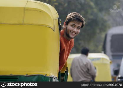Man looking out of an auto rickshaw
