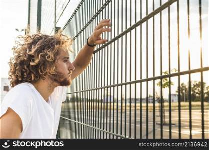 man looking through fence