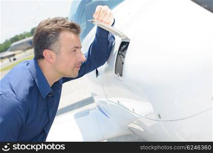Man looking through open flap on aircraft
