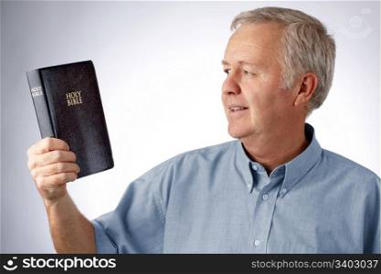 Man looking to the Bible in his hand (Open my eyes that I may see wonderful things in your law Psalm 119.18)