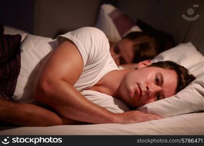 Man Lying Awake In Bed Suffering With Insomnia