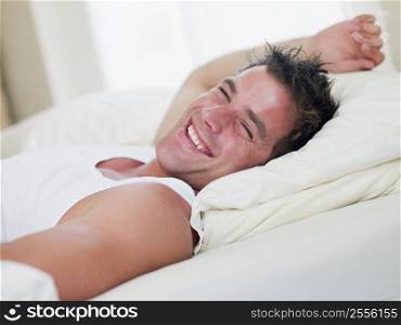 Man lying in bed laughing