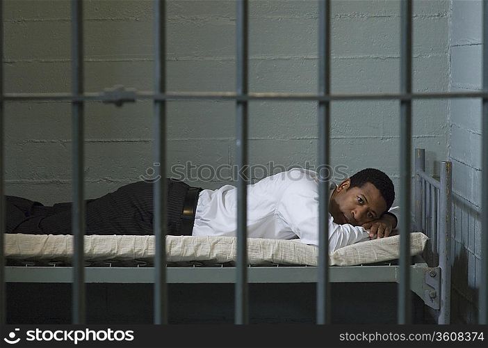 Man lying in prison cell