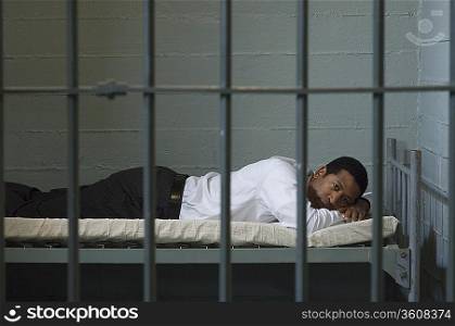 Man lying in prison cell