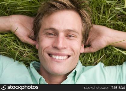 Man lying on grass smiling