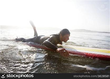 Man lying on surfboard in the water