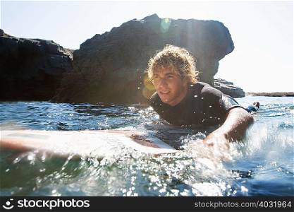 Man lying on surfboard in the water