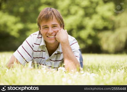 Man lying outdoors smiling