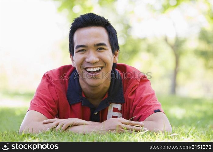 Man lying outdoors smiling