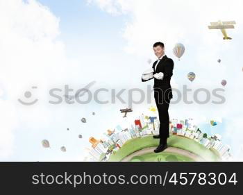 Man magician with cylinder hat. Young cheerful businessman making tricks with magic hat