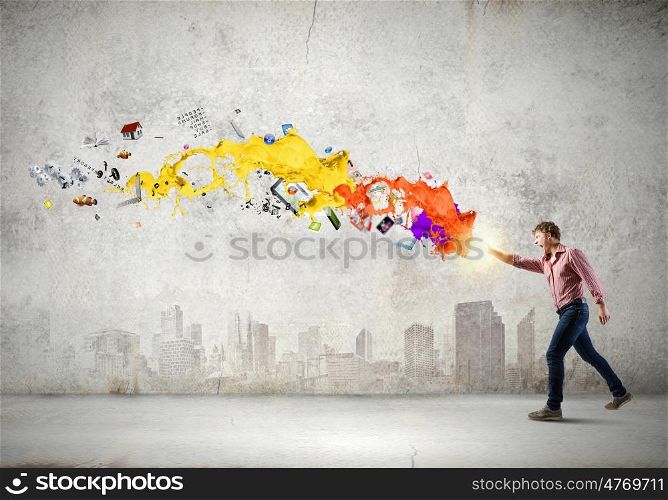 Man magician. Young man in casual throwing colorful paint splashes
