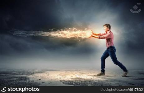 Man magician. Young man in casual throwing magic fire balls