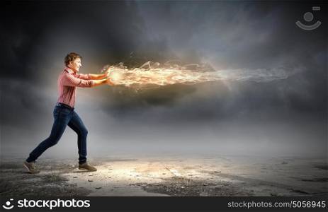 Man magician. Young man in casual throwing magic fire balls