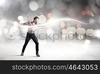 Man magician. Young man in casual throwing magic light