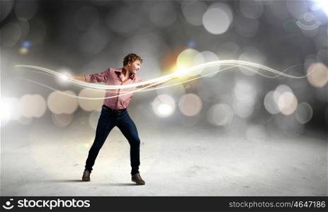 Man magician. Young man in casual throwing magic light