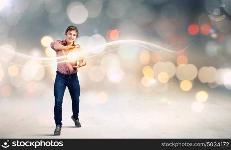 Man magician. Young man in casual throwing magic light