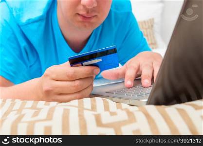 man makes an order in the Internet shop and pays card