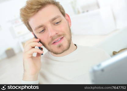 Man making a call whilst using his tablet computer