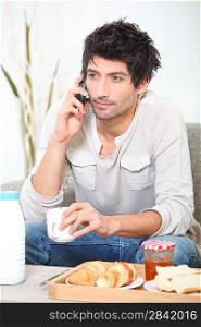 Man making a phone call over breakfast