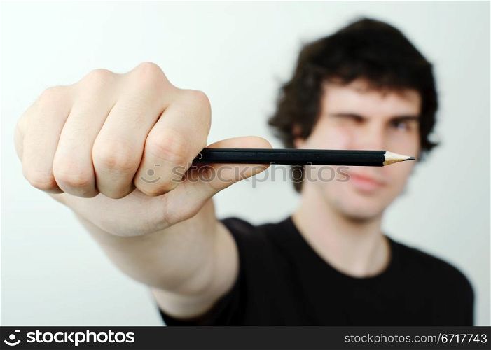 Man making eye-measure with pencil.