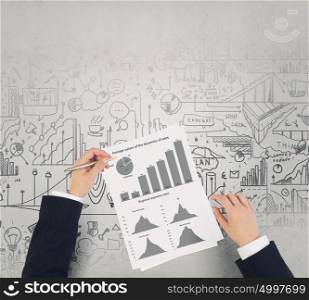 Man making financial notes. Businessman hands writing with pen infographs on paper