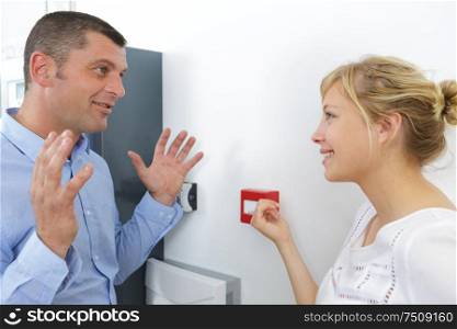 man making gesture of innocence by faire alarm box