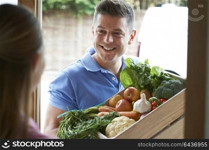 Man Making Home Delivery Of Organic Vegetable Box