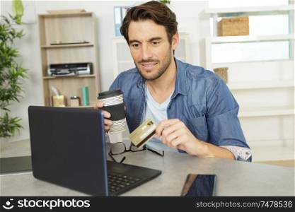 man making online payment with credit card and laptop