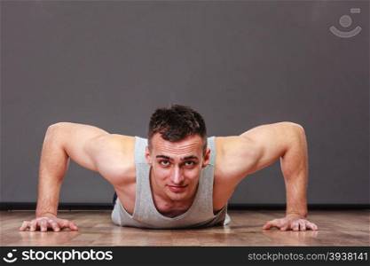Man making pushups,dark background. Care about health