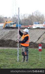 Man making taking measurements in construction site