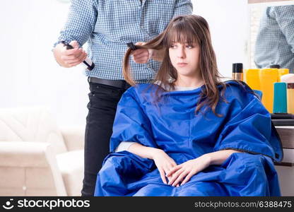 Man male hairdresser doing haircut for woman