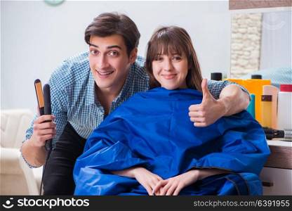 Man male hairdresser doing haircut for woman
