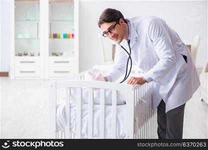 Man male pediatrician near baby bed preparing to examine