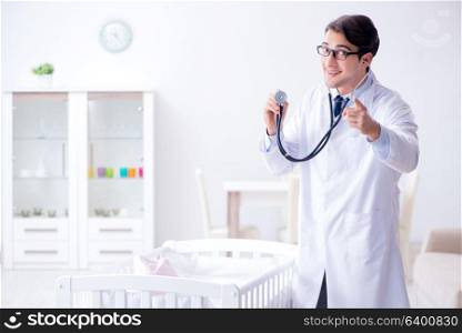Man male pediatrician near baby bed preparing to examine