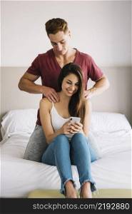 man massaging shoulder woman bed