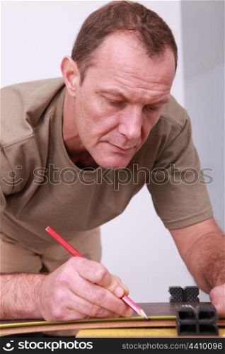 Man measuring and marking wood