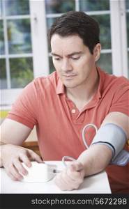 Man Measuring Blood Pressure At Home