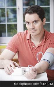 Man Measuring Blood Pressure At Home