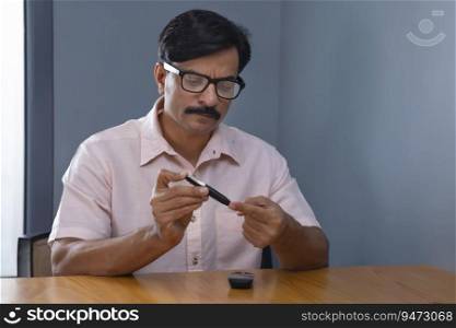 Man measuring blood sugar level through Glucometer at home
