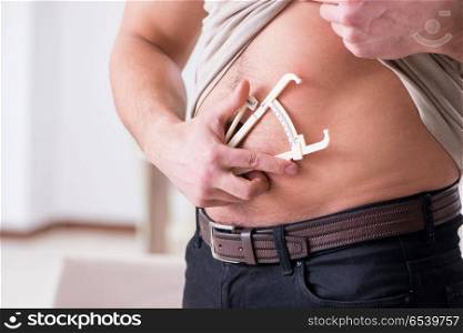 Man measuring body fat with calipers